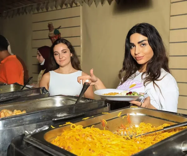 women getting dinner from buffet